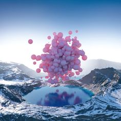 balloons floating in the air over a mountain lake