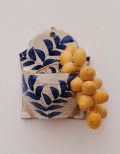 a blue and white bowl with grapes in it