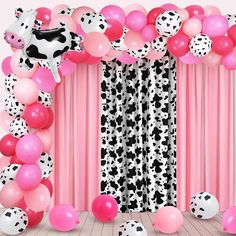 the balloon arch is decorated with black and white dalmatian print balloons, pink and white polka dots