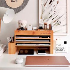 a desk with a laptop, mouse and other office supplies on it in front of a clock