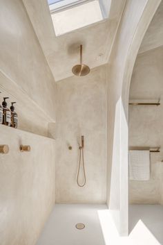 a bathroom with a skylight above the shower and toiletries on the wall next to it