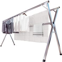 an ironing board with clothes hanging from it's sides and two racks holding shirts