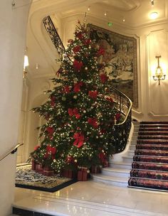 a decorated christmas tree sitting on top of a set of stairs