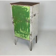 an old white and green cabinet with wooden top