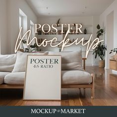 a white couch sitting in front of a poster on top of a wooden floor next to a window