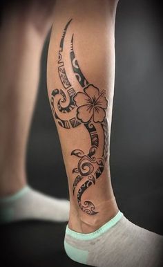 a woman's leg with a tattoo on it and flowers in the middle of her legs