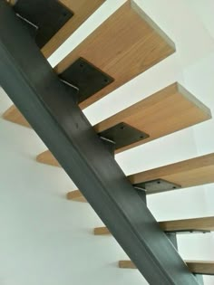 a wooden stair case with metal handrails and wood treading on the bottom