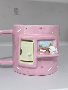 a pink coffee mug with an oven on the side and a white cat in it