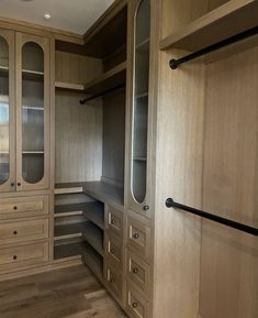 an empty walk - in closet with wooden cabinets and drawers