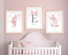 a baby's room with pink walls and pictures on the wall, including a crib