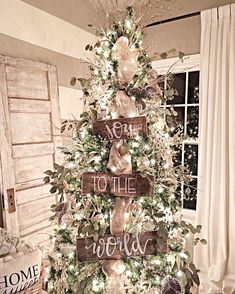 a christmas tree decorated with wooden signs and greenery