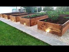 several wooden raised garden beds with lights on them