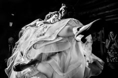 black and white photograph of a woman in a wedding dress being lifted by a man