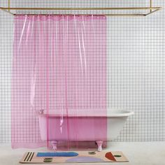 a pink shower curtain hanging over a bathtub