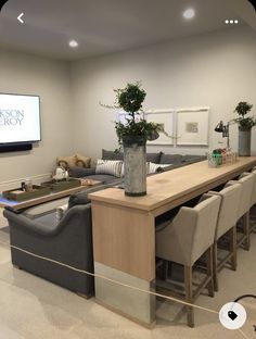 a living room filled with furniture and a flat screen tv mounted to the side of a wall