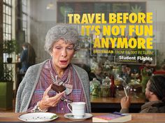 an older woman eating food at a table with a book and coffee cup in front of her