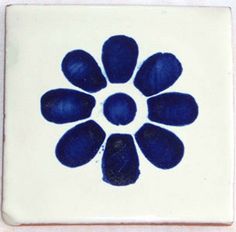 a blue and white tile with a flower design on the bottom, in square shape