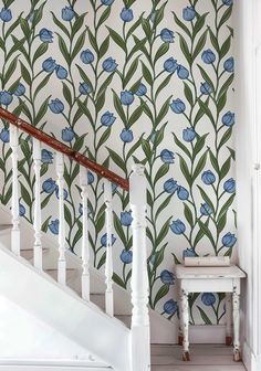 a stair case next to a wall with blue flowers on it