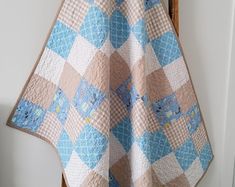 a blue and white quilt hanging on the wall