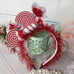 a red and white headband with candy canes on it, surrounded by flowers