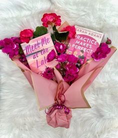 a bouquet of pink flowers and books on a white furnishing