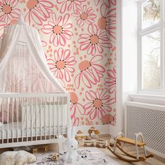 a baby's room decorated in pink and white with flowers on the wall behind it