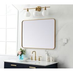 a bathroom vanity with a large mirror and two faucets on the wall next to it