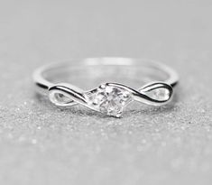 a white gold ring with a diamond in the center and a twisted band around it