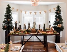 a table is decorated with christmas trees and candles