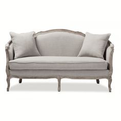 a couch with three pillows on it and two pillow cases in the back, one is grey