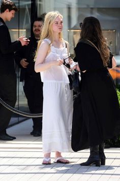 two women in white dresses talking to each other