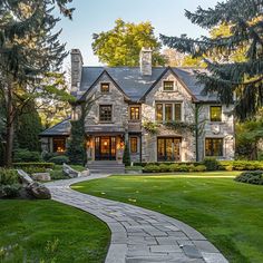 a large stone house surrounded by trees and grass