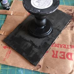 a black object sitting on top of a piece of brown paper