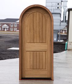 an open wooden door sitting on top of a cement floor in front of a building