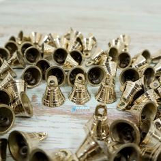 many brass bells are laying on the table