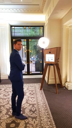 a man in a suit standing next to an electronic device