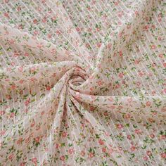 a close up view of a flowery fabric with pink and green flowers on it