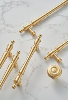 four golden handles and two knobs on a marble surface