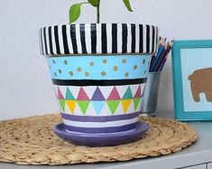 a potted plant sitting on top of a wooden table next to a framed picture