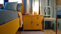 a bedroom with yellow furniture and blue walls