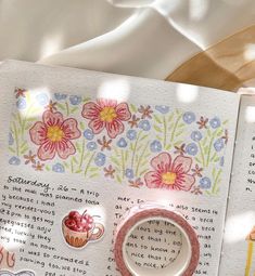 an open book with stickers on it and some papers next to it that have flowers in them