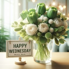 a vase filled with white flowers sitting on top of a table next to a sign that says happy wednesday