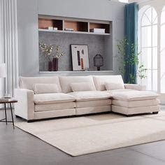 a living room with a large white couch and rugs on the floor in front of it