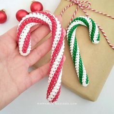 a hand is holding two christmas candy canes