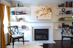 a living room filled with furniture and a fire place under a painting on the wall