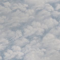 an airplane is flying high in the sky with clouds around it and one plane on the ground