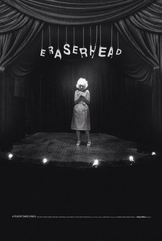 a black and white photo of a woman standing on stage with the words erasehead above her head