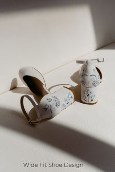 a pair of white shoes sitting on top of a bed