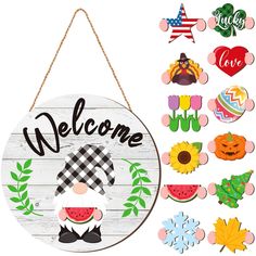 a welcome sign hanging from the side of a white wooden wall next to other decorations