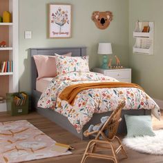 a bed room with a neatly made bed and a teddy bear hanging on the wall